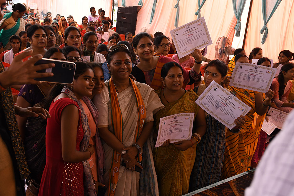 Honarable Kshipra Shukla taking a picture with a group of women and the women were holding the certificate to distribute at the closing program of ODOP Gorakhpur.